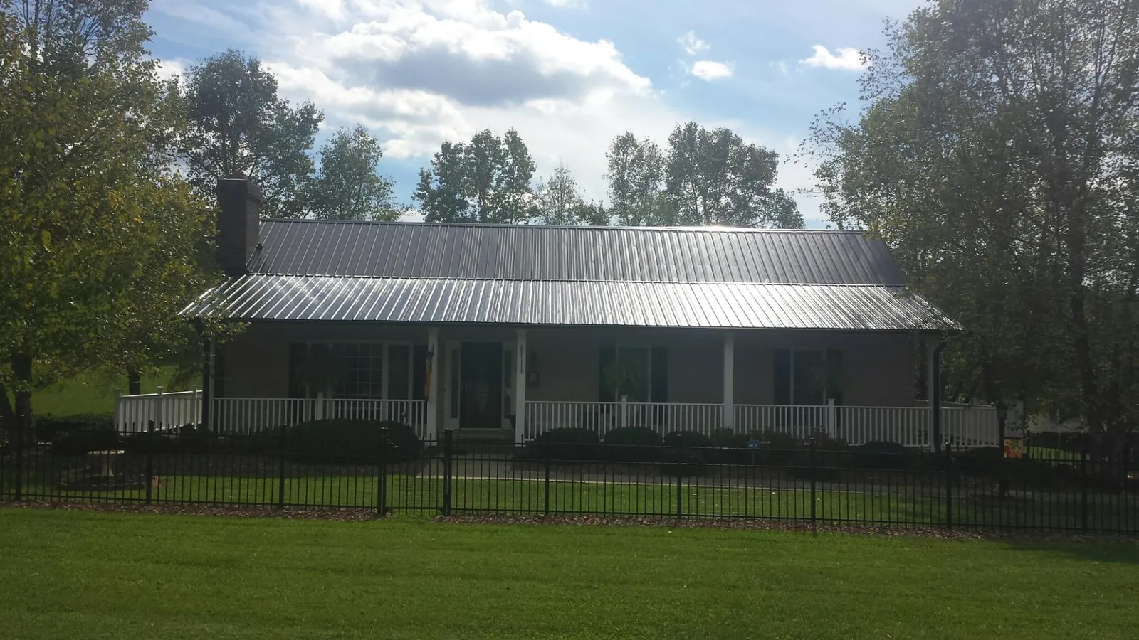 Gray metal roof on a brick ranch with a full width front porch — Gutter Guard Installation work by our crew in Grosse Pointe